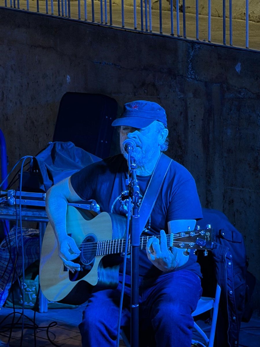 Primer plano de Petrus cantando y tocando la guitarra acústica